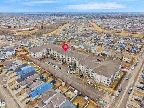 The property is a multi-story building featuring a prominent brown roof and light-colored exterior walls - 106 2305 35A Avenue Nw, Edmonton, AB - Outdoor With View