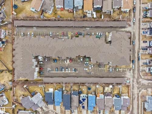 Aerial view of the property with a large parking area, surrounded by residential structures - 106 2305 35A Avenue Nw, Edmonton, AB - Other
