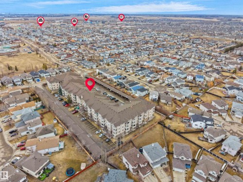 Aerial view of the property with a large parking area, surrounded by a residential neighborhood - 106 2305 35A Avenue Nw, Edmonton, AB - Outdoor With View