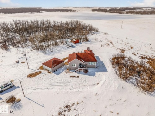 The property features a primary residence with a red roof and an exterior in a light neutral tone - 160068 Twp 531, Rural Lamont County, AB - Outdoor With View