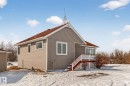 The property features a peaked roof with red shingles, light grey siding, and white window frames - 160068 Twp 531, Rural Lamont County, AB  - Outdoor With Exterior 