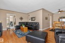 This living area features hardwood floors and a ceiling fan, with a dining area visible in the background - 160068 Twp 531, Rural Lamont County, AB  - Indoor Photo Showing Living Room 