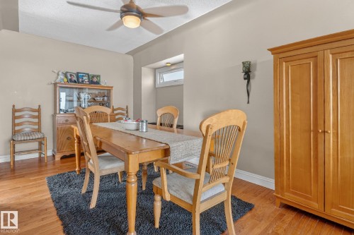 The dining area features hardwood flooring, a ceiling fan with integrated lighting, and a window providing natural light - 160068 Twp 531, Rural Lamont County, AB - Indoor Photo Showing Dining Room