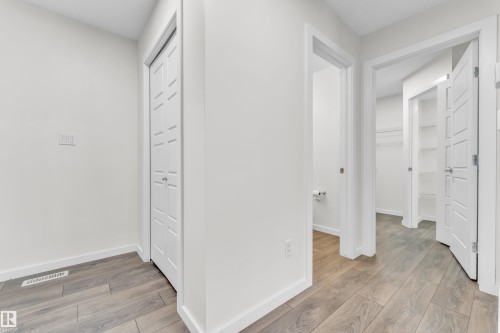 The property features light-colored walls and wood-look flooring throughout - 4416 6 Street, Edmonton, AB - Indoor Photo Showing Other Room