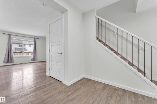 The entryway features hardwood flooring and a staircase with a modern railing and carpeted steps - 4416 6 Street, Edmonton, AB - Indoor Photo Showing Other Room