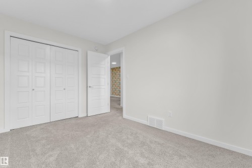 This room features light grey carpeting and light-colored walls - 4416 6 Street, Edmonton, AB - Indoor Photo Showing Other Room