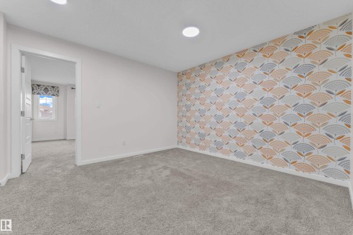 Room featuring patterned accent wall, white walls, and gray carpeting - 4416 6 Street, Edmonton, AB - Indoor Photo Showing Other Room