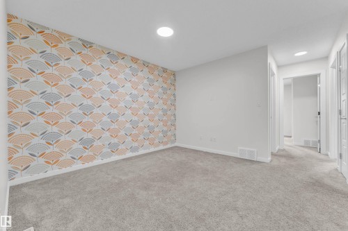 Room featuring a decorative accent wall with a geometric pattern, light grey carpeting, and recessed lighting - 4416 6 Street, Edmonton, AB - Indoor Photo Showing Other Room