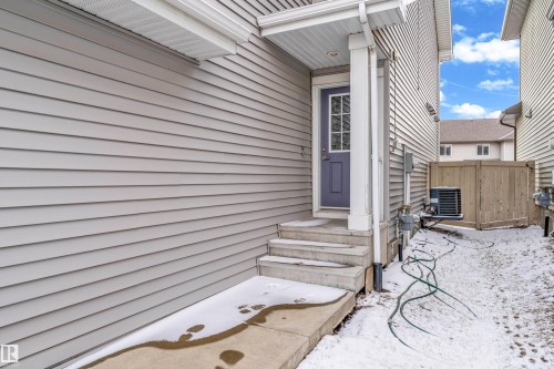The property features light gray horizontal siding and a dark gray entry door with glass panels - 4416 6 Street, Edmonton, AB - Outdoor With Deck Patio Veranda With Exterior