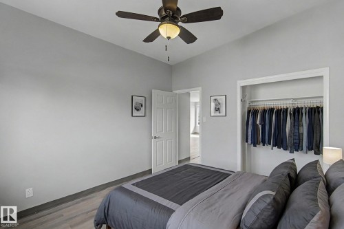 This room features light-colored walls, a ceiling fan with integrated lighting, and light wood-style flooring - 5920 132 Avenue, Edmonton, AB - Indoor Photo Showing Bedroom