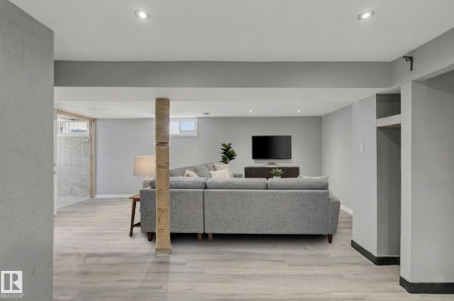 This living area features light-toned flooring, recessed lighting, and a neutral wall color throughout, offering a versatile space - 5920 132 Avenue, Edmonton, AB - Indoor