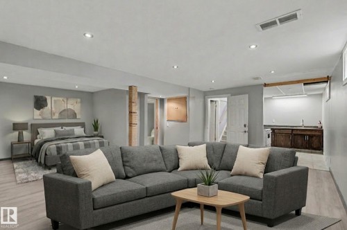 Versatile open-concept room featuring light-colored flooring, recessed lighting, and a well-appointed second kitchen area with dark wood cabinetry and a stainless steel sink - 5920 132 Avenue, Edmonton, AB - Indoor Photo Showing Living Room
