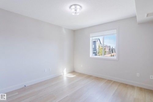 This 2nd bedroom features light-colored flooring, neutral wall tones, and a window with blinds providing natural illumination - 209 14612 125 Street, Edmonton, AB - Indoor Photo Showing Other Room
