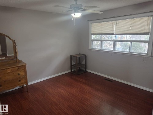 The room features rich, reddish-brown flooring, light gray walls, and white baseboards - 3626 111 Avenue, Edmonton, AB - Indoor Photo Showing Other Room