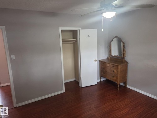 The room features rich hardwood flooring, a ceiling fan with integrated lighting, and a closet with shelving - 3626 111 Avenue, Edmonton, AB - Indoor Photo Showing Other Room