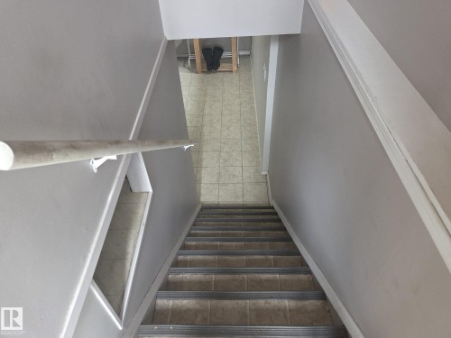 Stairwell with light grey walls, a white handrail, and tiled flooring at the base - 3626 111 Avenue, Edmonton, AB - Indoor Photo Showing Other Room