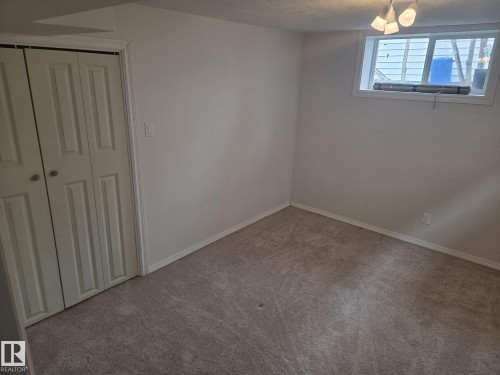 This room features light-colored carpeting, white walls, and a window providing natural light - 3626 111 Avenue, Edmonton, AB - Indoor Photo Showing Other Room