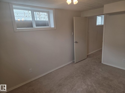 This room features light-colored walls and a neutral-toned carpet, providing a versatile backdrop - 3626 111 Avenue, Edmonton, AB - Indoor Photo Showing Other Room