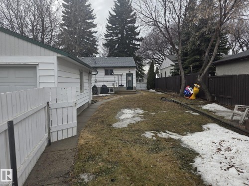 The property features a spacious backyard with a large lawn area and mature trees - 3626 111 Avenue, Edmonton, AB - Outdoor