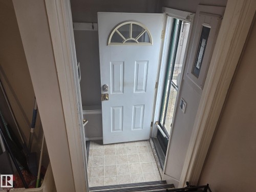 Entryway featuring a white door with an arched window, tiled flooring, and a storm door - 3626 111 Avenue, Edmonton, AB - Indoor Photo Showing Other Room