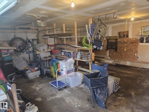 The property features a garage with exposed support beams and an overhead door mechanism - 3626 111 Avenue, Edmonton, AB - Indoor