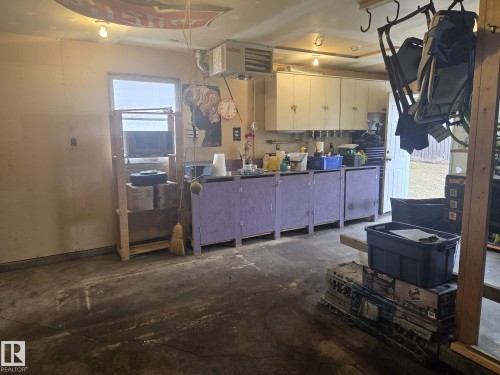 This workspace features overhead lighting, a window, and both upper and lower cabinetry, providing ample storage and a functional area - 3626 111 Avenue, Edmonton, AB - Indoor