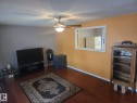 Living area with warm-toned walls, a ceiling fan with integrated lighting, and wood-look flooring - 3626 111 Avenue, Edmonton, AB  - Indoor Photo Showing Other Room 