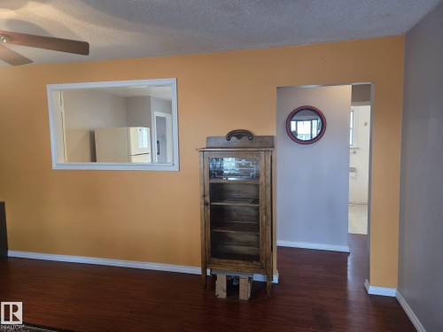 Living area featuring warm-toned walls, dark wood flooring, and a ceiling fan - 3626 111 Avenue, Edmonton, AB - Indoor Photo Showing Other Room