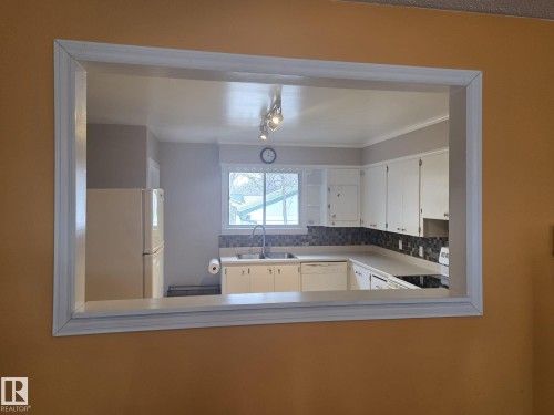 Kitchen featuring white cabinetry, a window above the sink, a tiled backsplash, and recessed lighting - 3626 111 Avenue, Edmonton, AB - Indoor