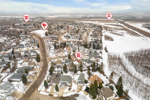 Aerial view highlighting the property within a residential district, featuring snow-covered landscapes and surrounding natural areas - 10 Harmony Place, St. Albert, AB - Outdoor With View