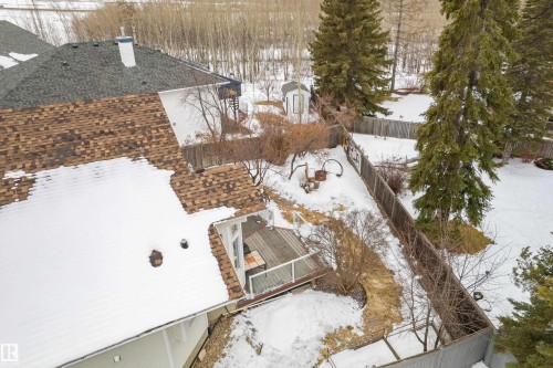 The property features a brown shingle roof, a fenced yard, and a deck with a white railing - 10 Harmony Place, St. Albert, AB - Outdoor