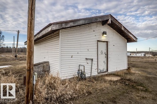 White horizontal vinyl siding on a single-story structure with a brown shingle roof - 57027 Sec Hwy 881, Rural St. Paul County, AB 