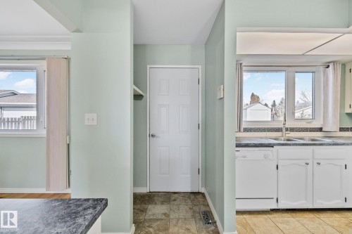 The kitchen features white cabinetry, a double basin sink, and a dishwasher - 2016 138 Avenue, Edmonton, AB - Indoor