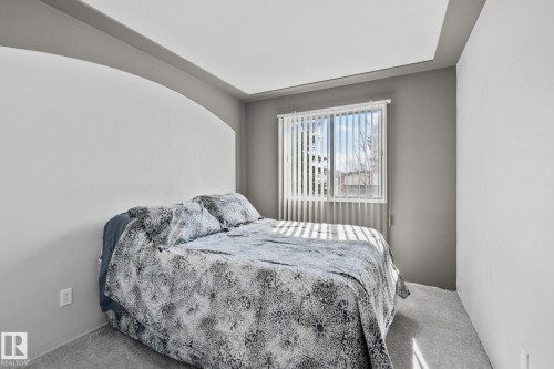 Bedroom featuring light grey walls, a tray ceiling, and a window with vertical blinds - 2016 138 Avenue, Edmonton, AB - Indoor Photo Showing Bedroom