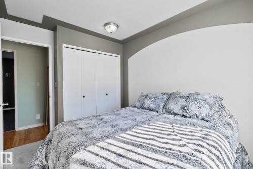 This room offers a ceiling light fixture, a closet with bi-fold doors, and a wall with an arched detail - 2016 138 Avenue, Edmonton, AB - Indoor Photo Showing Bedroom