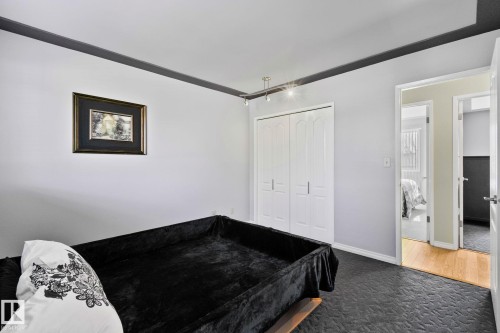 The room features light-colored walls and dark trim, with a dark patterned carpet - 2016 138 Avenue, Edmonton, AB - Indoor Photo Showing Bedroom