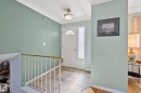 Entryway featuring tiled flooring, a white front door with an arched window, and a white handrail with a brass-toned top - 2016 138 Avenue, Edmonton, AB  - Indoor Photo Showing Other Room 