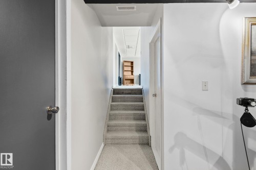 Inviting hallway with light gray carpeted stairs and white walls - 2016 138 Avenue, Edmonton, AB - Indoor
