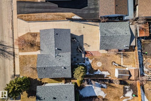 This property features a gray shingle roof, a paved driveway, and a backyard with a shed - 2016 138 Avenue, Edmonton, AB - Outdoor