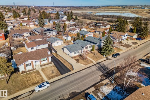 Aerial view of the property and its surrounding neighborhood, featuring a paved street, residential homes with various roof styles, and scattered trees - 2016 138 Avenue, Edmonton, AB - Outdoor With View