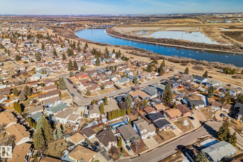 Aerial view showcasing a residential area with varied housing styles, mature trees, and a river winding through the landscape - 2016 138 Avenue, Edmonton, AB - Outdoor With View