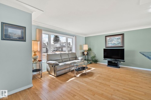 The living area features hardwood floors and a large window, providing natural light - 2016 138 Avenue, Edmonton, AB - Indoor Photo Showing Living Room