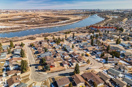 The property is situated within a developed residential area featuring various housing styles and roof colors, with mature trees visible throughout - 2016 138 Avenue, Edmonton, AB - Outdoor With View