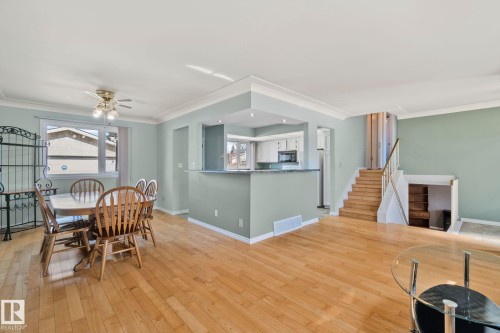 Living area featuring hardwood floors, light green walls, and a view of the kitchen with a half-wall and countertop - 2016 138 Avenue, Edmonton, AB - Indoor Photo Showing Dining Room