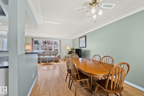 This inviting dining area features hardwood floors and a ceiling fan with light fixtures - 2016 138 Avenue, Edmonton, AB - Indoor Photo Showing Dining Room