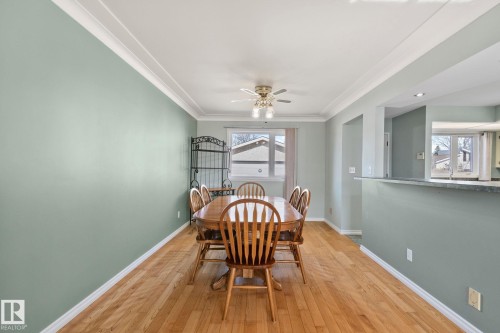 This bright dining area features hardwood floors and a ceiling fan with integrated lighting - 2016 138 Avenue, Edmonton, AB - Indoor Photo Showing Dining Room