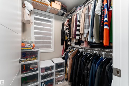 Walk-in closet featuring wire shelving, hanging rods, and a window with horizontal blinds - 22742 95A Ave, Edmonton, AB - Indoor With Storage