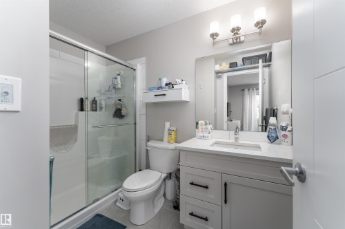 Bathroom featuring a white vanity with a rectangular sink, a glass-enclosed shower, and a toilet - 22742 95A Ave, Edmonton, AB - Indoor Photo Showing Bathroom