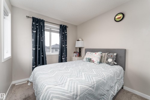 This room features light-colored walls, carpeted flooring, and a large window providing natural light - 22742 95A Ave, Edmonton, AB - Indoor Photo Showing Bedroom
