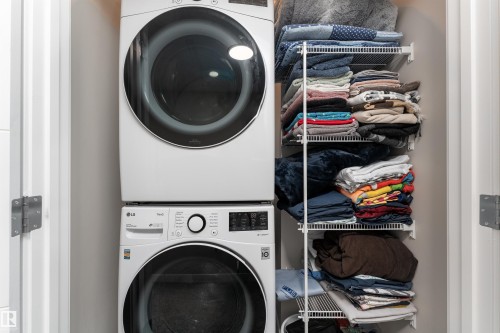 Laundry area featuring a stacked washer and dryer, and wire shelving for storage - 22742 95A Ave, Edmonton, AB - Indoor Photo Showing Laundry Room